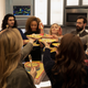 On board the Waverider, the Legends of Tomorrow stand in a circle and toast each other with plates of cake.
